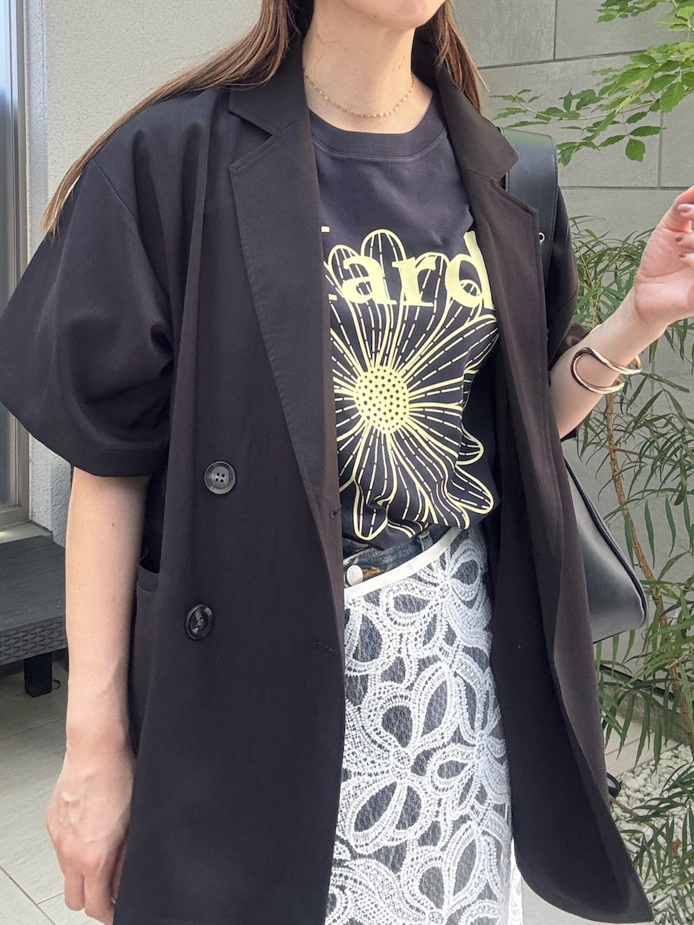 ブラック系のテーラードジャケット、ブルー系のデニムパンツ、ブルー系のTシャツ/カットソーを着用したレディースの秋コーディネートの3枚目の写真