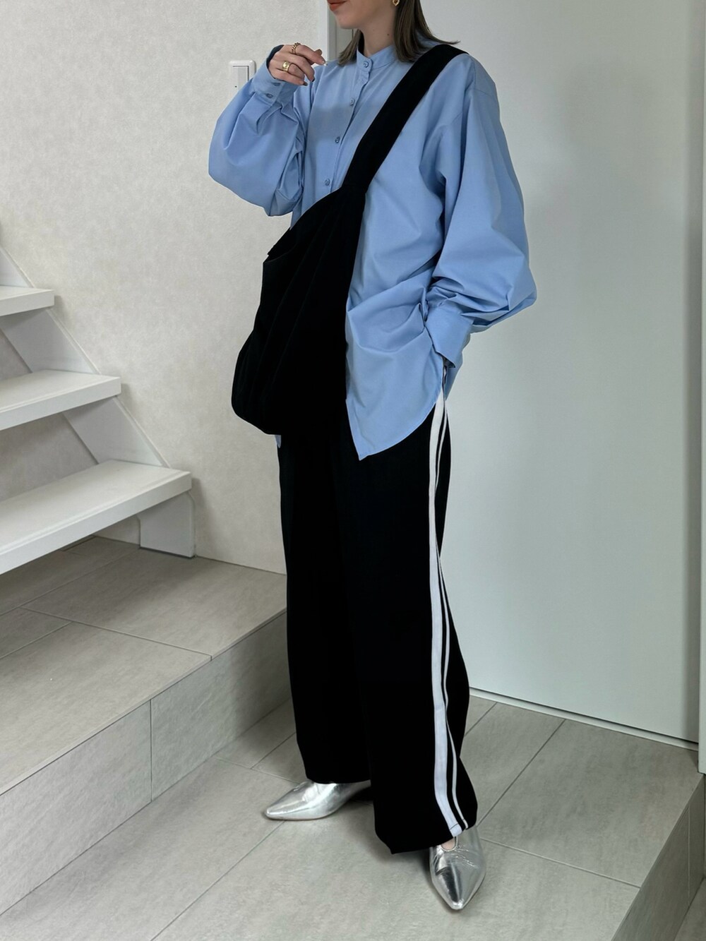 ブルー系のシャツ/ブラウス、ブラック系のスラックス、シルバー系のパンプスを着用したレディースの冬コーディネートの5枚目の写真