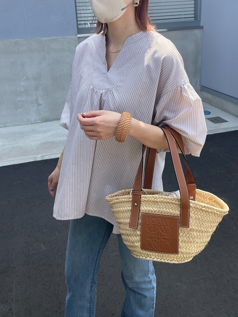 ベージュ系のシャツ/ブラウス、ブラウン系のトートバッグ、ブルー系のデニムパンツを着用したレディースの春コーディネートの5枚目の写真