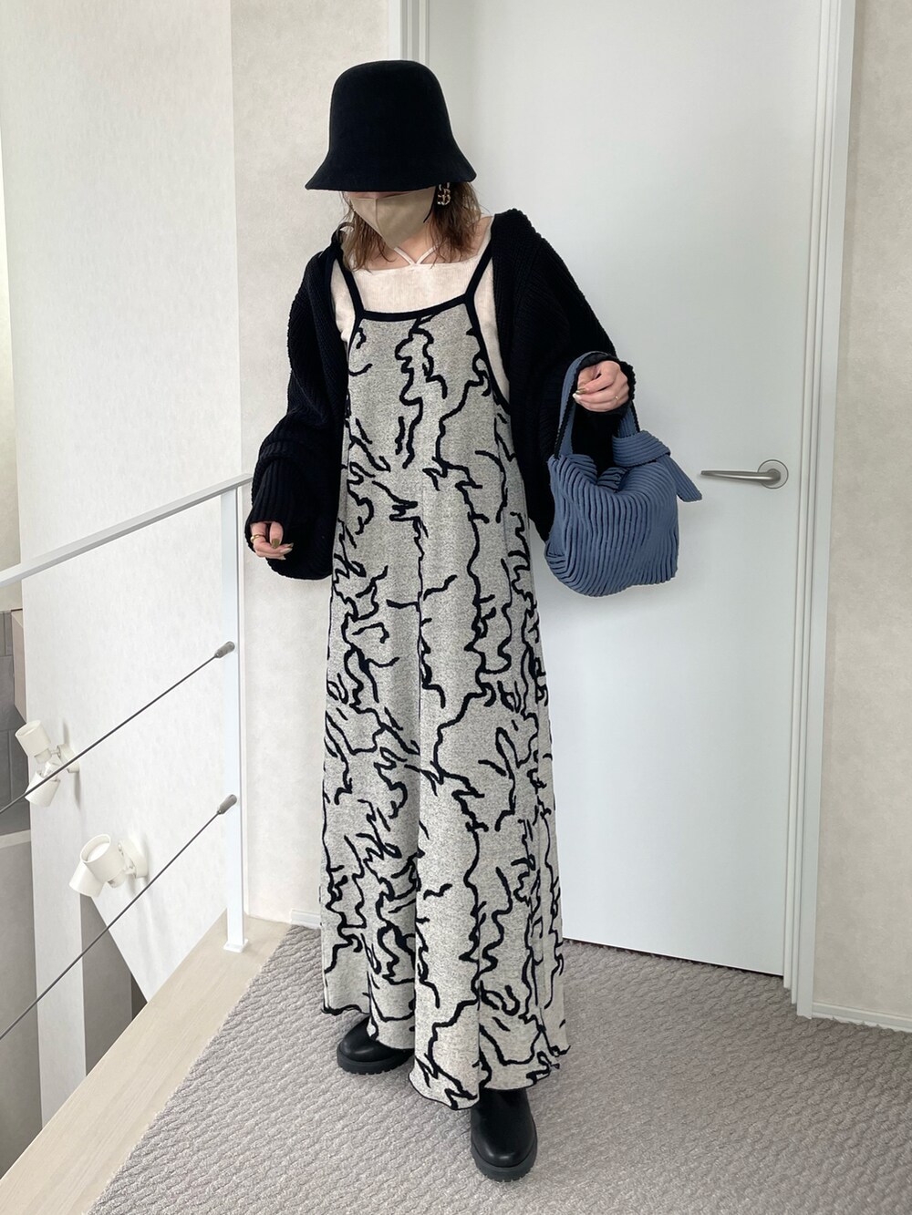 ホワイト系のワンピース、ホワイト系のニット/セーター、ブルー系のハンドバッグを着用したレディースの冬コーディネートの2枚目の写真