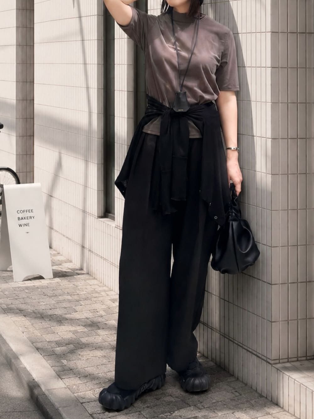グレー系のTシャツ/カットソー、ブラック系のショルダーバッグ、ブラック系のカーディガン/ボレロを着用したレディースの夏コーディネートの2枚目の写真