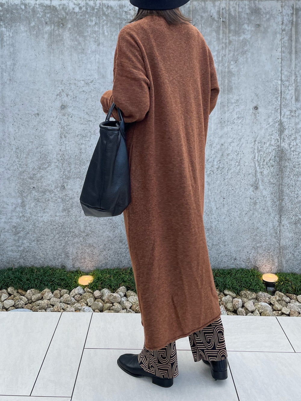 ブラウン系のワンピース、ブラック系のトートバッグ、ブラック系のその他シューズを着用したレディースの秋コーディネートの4枚目の写真