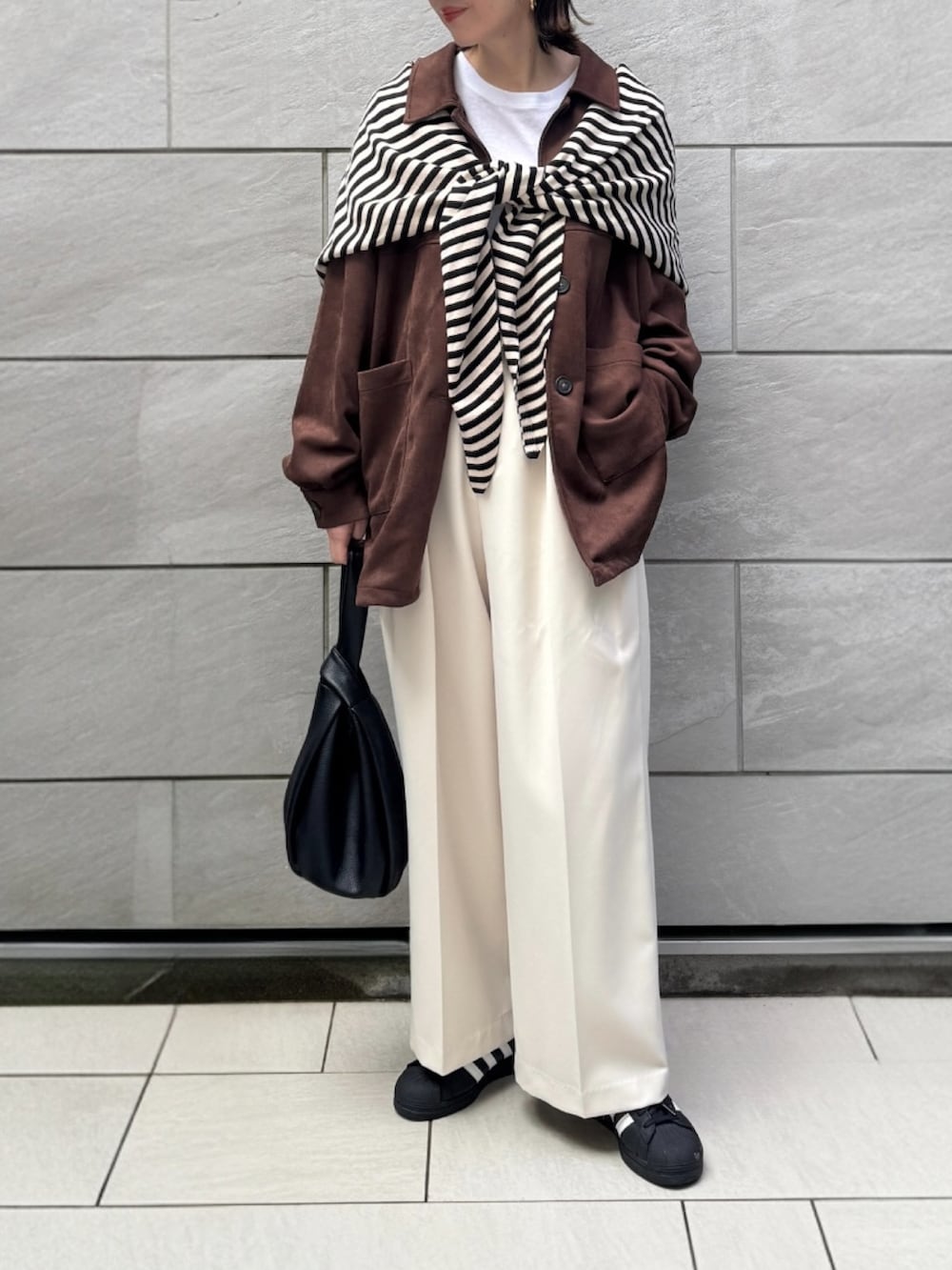 ブラウン系のその他アウター、ホワイト系のTシャツ/カットソー、ブラック系のスニーカーを着用したレディースの冬コーディネートの3枚目の写真