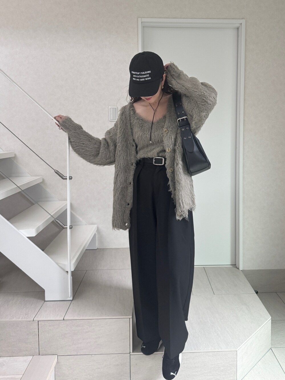 グレー系のカーディガン/ボレロ、ブラック系のスニーカー、ブラック系のハンドバッグを着用したレディースの秋コーディネートの5枚目の写真