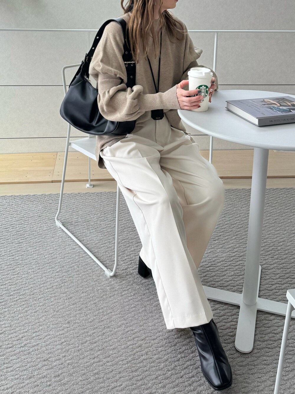ブラック系のハンドバッグ、ベージュ系のニット/セーター、ホワイト系のその他パンツを着用したレディースの冬コーディネートの3枚目の写真