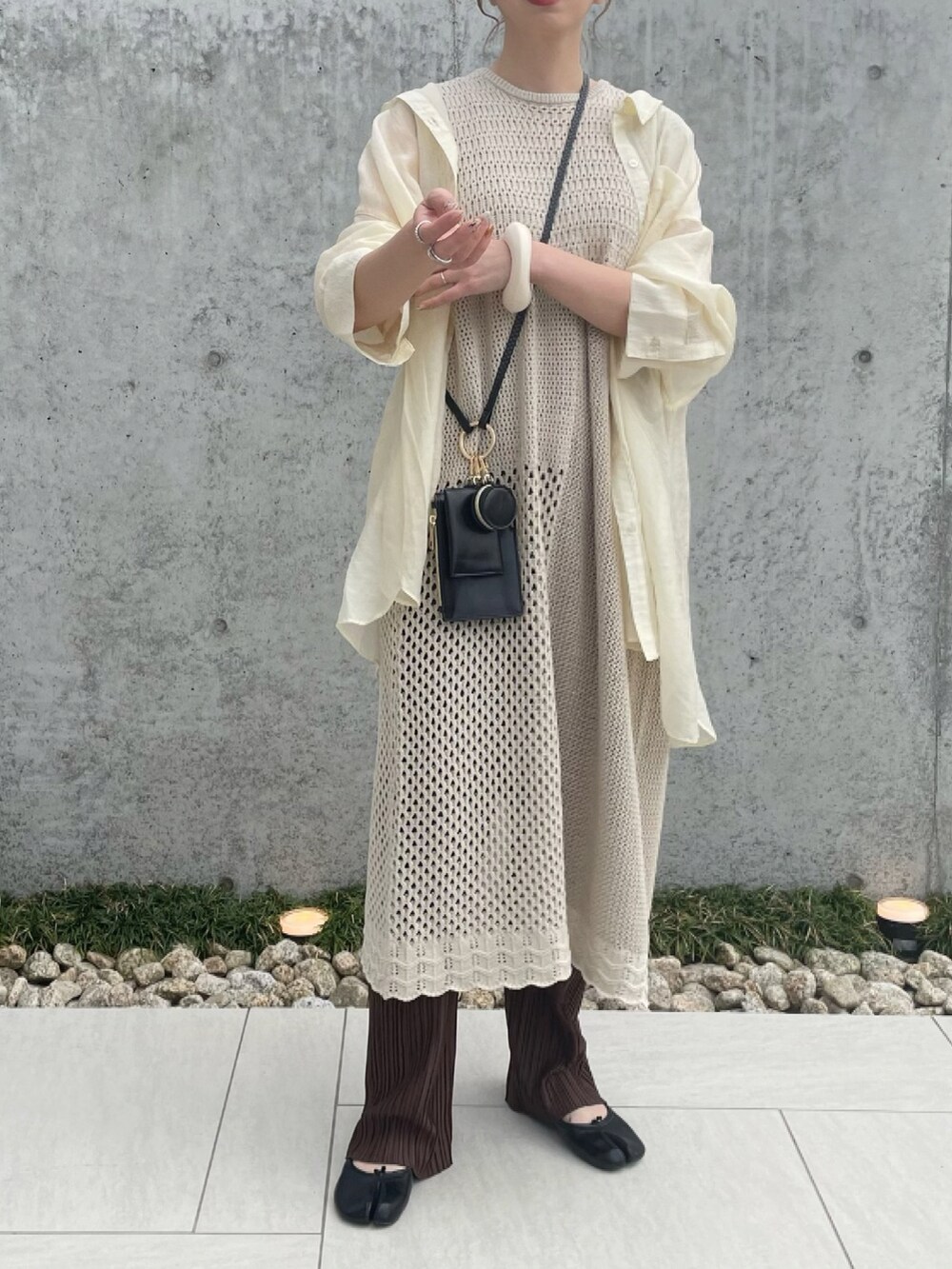 ホワイト系のニット/セーター、ブラック系のショルダーバッグ、ブラック系のパンプスを着用したレディースの春コーディネートの3枚目の写真