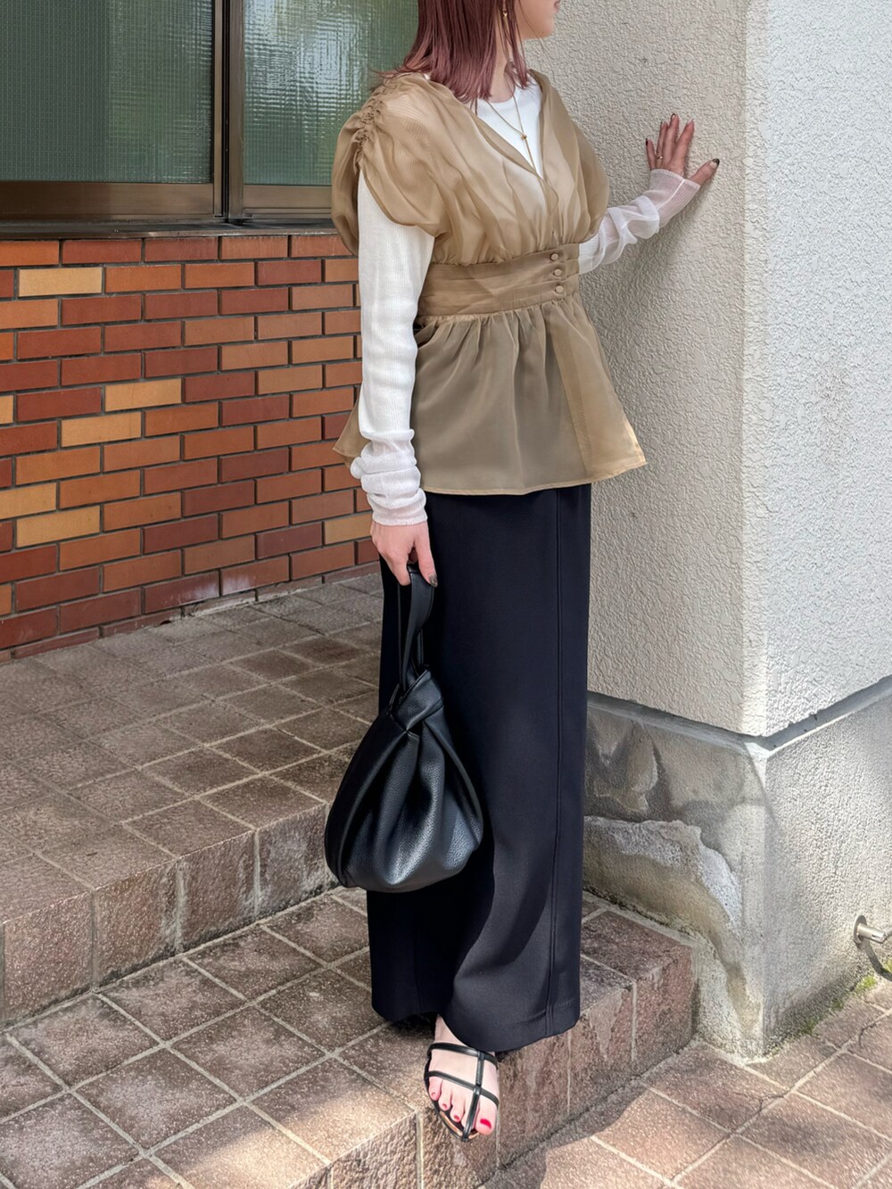ベージュ系のTシャツ/カットソー、ブラック系のサンダル、ブラック系のスカートを着用したレディースの春コーディネートの3枚目の写真