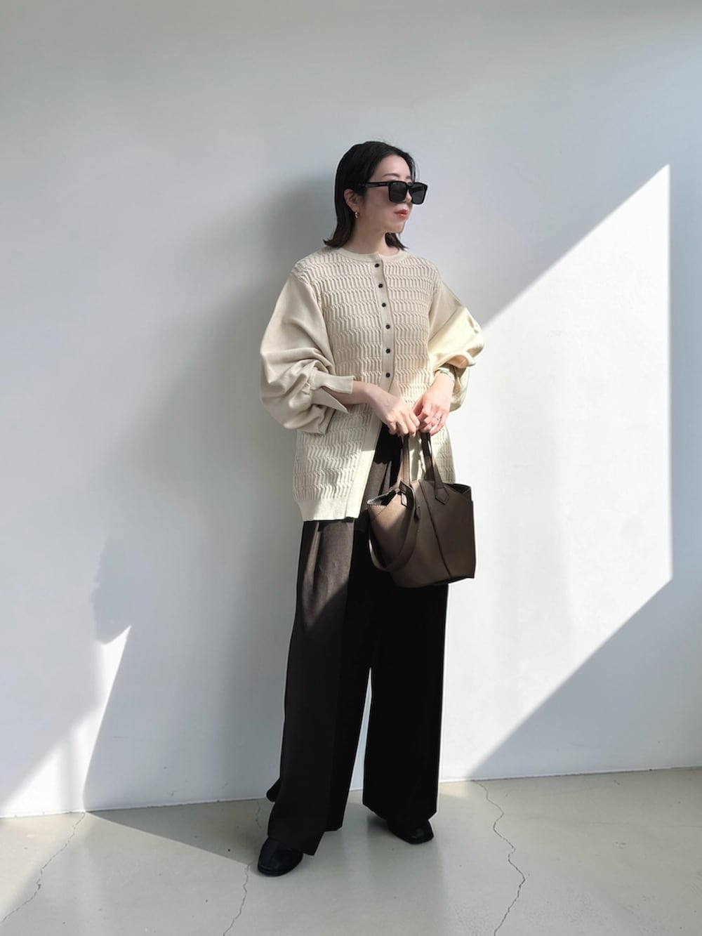 ブラウン系のその他パンツ、ホワイト系のカーディガン/ボレロ、ブラウン系のショルダーバッグを着用したレディースの春コーディネートの3枚目の写真