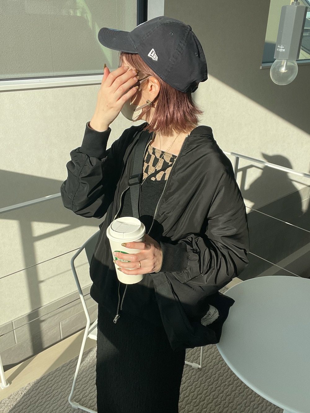 グリーン系のMA-1、ブラウン系のキャミソール、ブラック系のワンピースを着用したレディースの春コーディネートの3枚目の写真