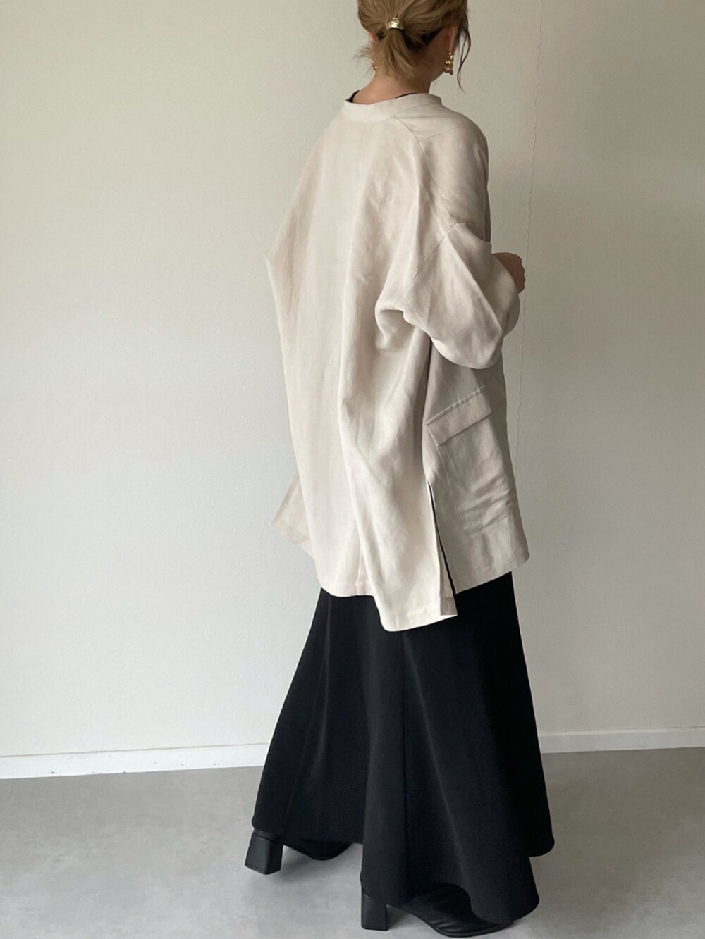 ベージュ系のその他アウター、ブラック系のスカート、ブラウン系のショルダーバッグを着用したレディースの冬コーディネートの3枚目の写真