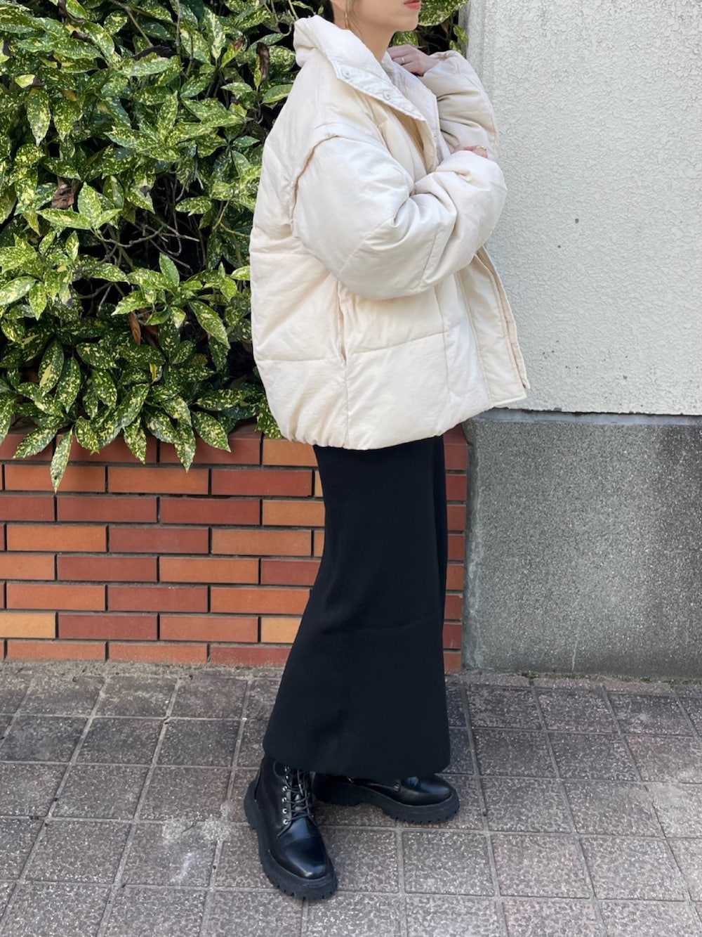 ホワイト系のその他アウター、ブラック系のスカート、ブラック系のブーツを着用したレディースの秋コーディネートの3枚目の写真