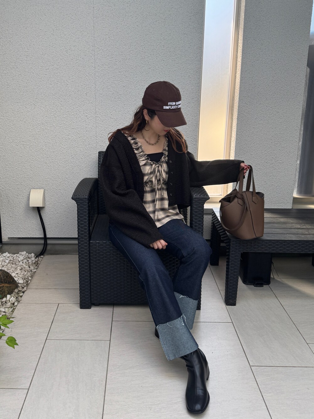 ブラック系のカーディガン/ボレロ、ブラウン系のシャツ/ブラウス、ブラウン系のキャップを着用したレディースの秋コーディネートの2枚目の写真
