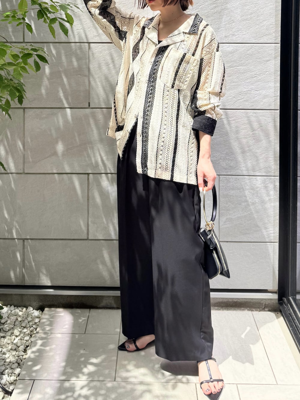 ホワイト系のシャツ/ブラウス、ブラック系のサンダル、ブラック系のその他パンツを着用したレディースの春コーディネートの2枚目の写真