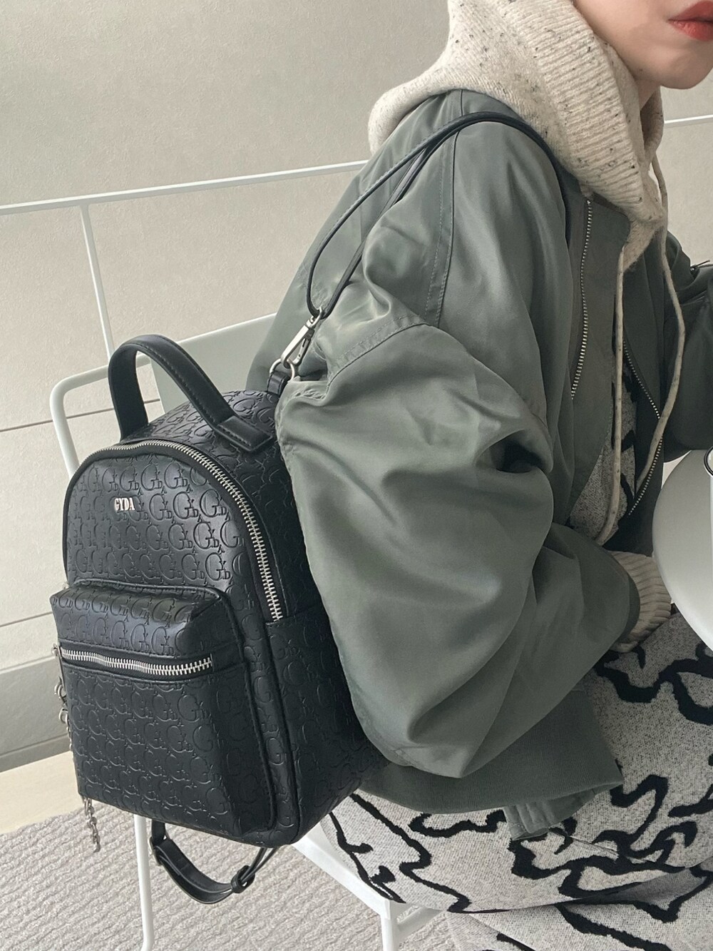 ブラック系のバックパック/リュック、ホワイト系のワンピース、グリーン系のブルゾンを着用したレディースの冬コーディネートの4枚目の写真