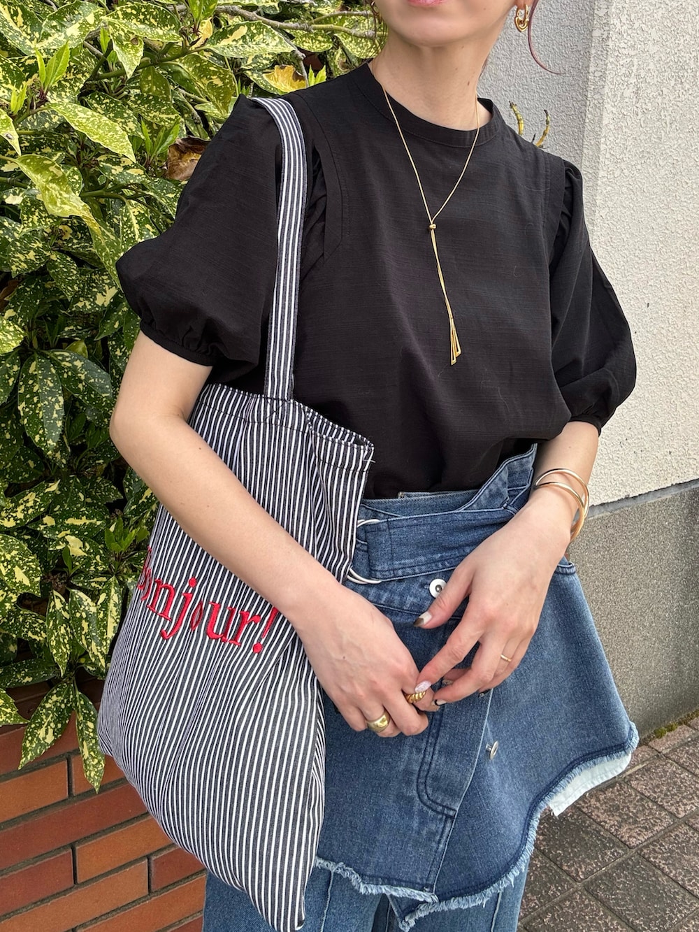 ブラック系のシャツ/ブラウス、ブラック系のトートバッグ、ブルー系のデニムパンツを着用したレディースの春コーディネートの5枚目の写真