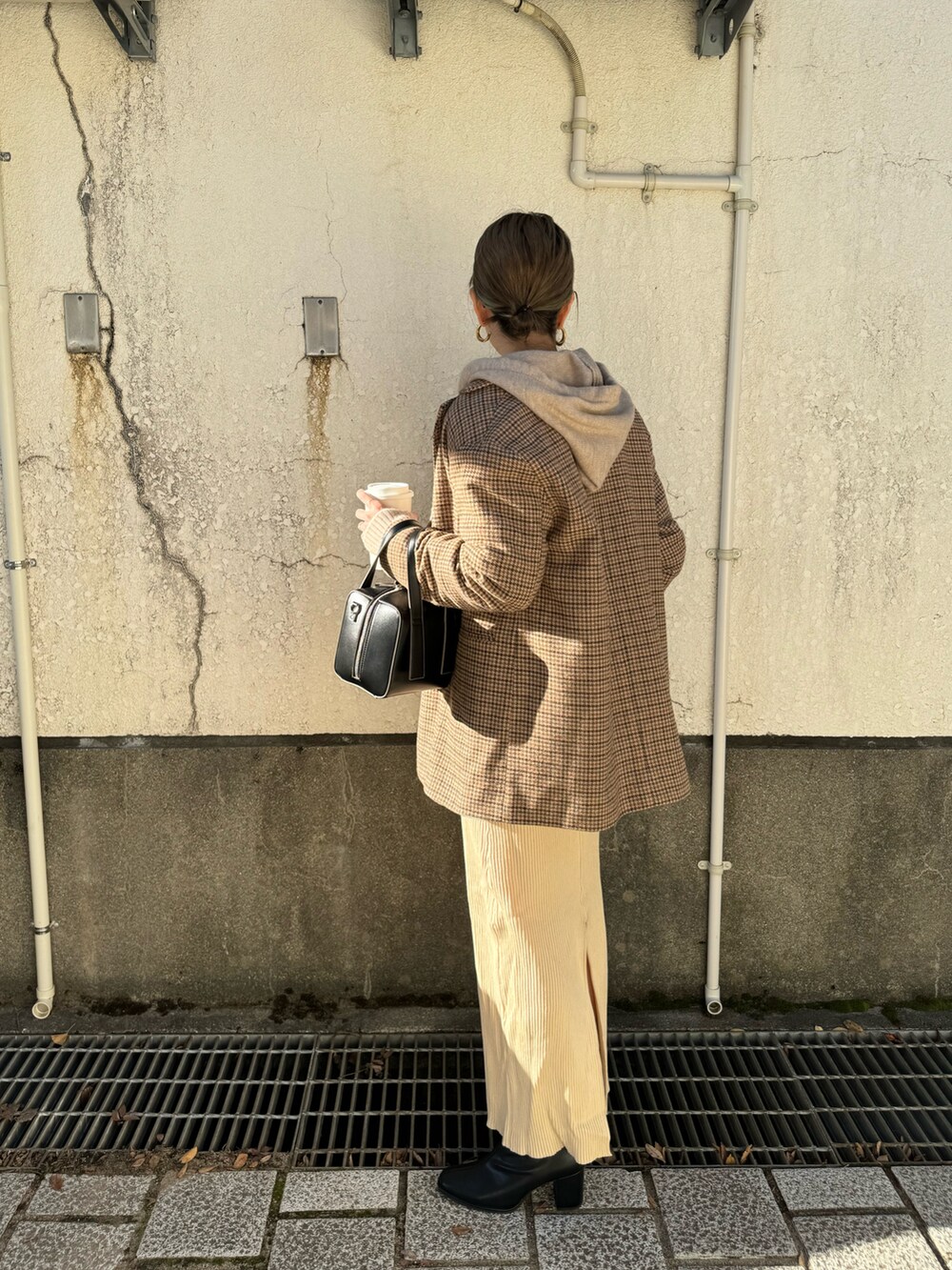 ホワイト系のワンピース、ブラック系のボストンバッグ、ベージュ系のニット/セーターを着用したレディースの秋コーディネートの5枚目の写真