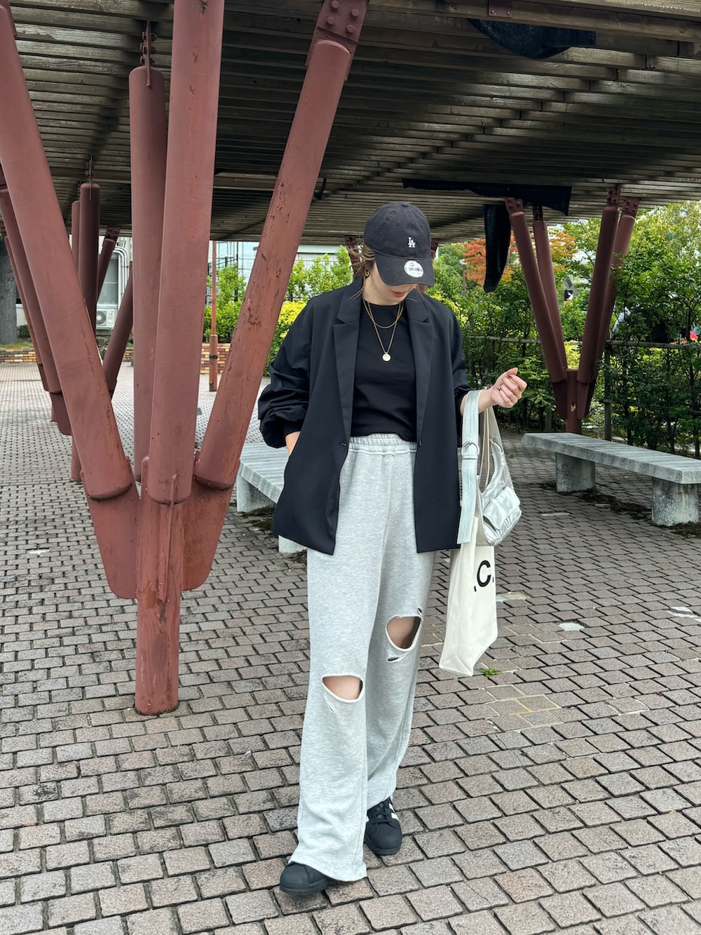 グレー系のスウェットパンツ、ブラック系のスニーカー、ホワイト系のトートバッグを着用したレディースの秋コーディネートの4枚目の写真