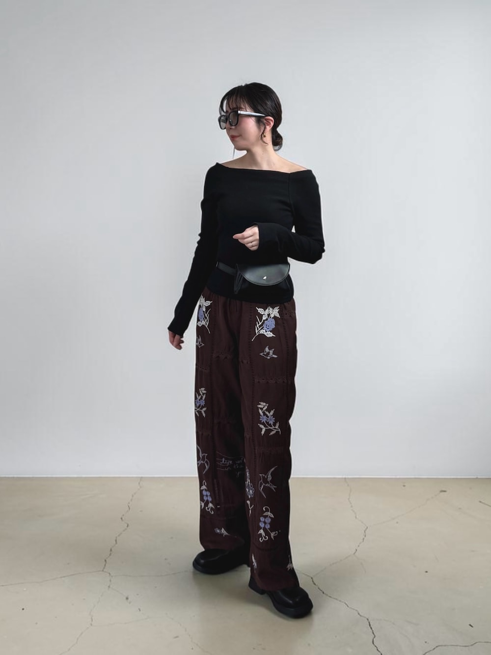 ブラック系のその他シューズ、ブラック系のボディバッグ/ウエストポーチ、ブラック系のTシャツ/カットソーを着用したレディースの春コーディネートの3枚目の写真