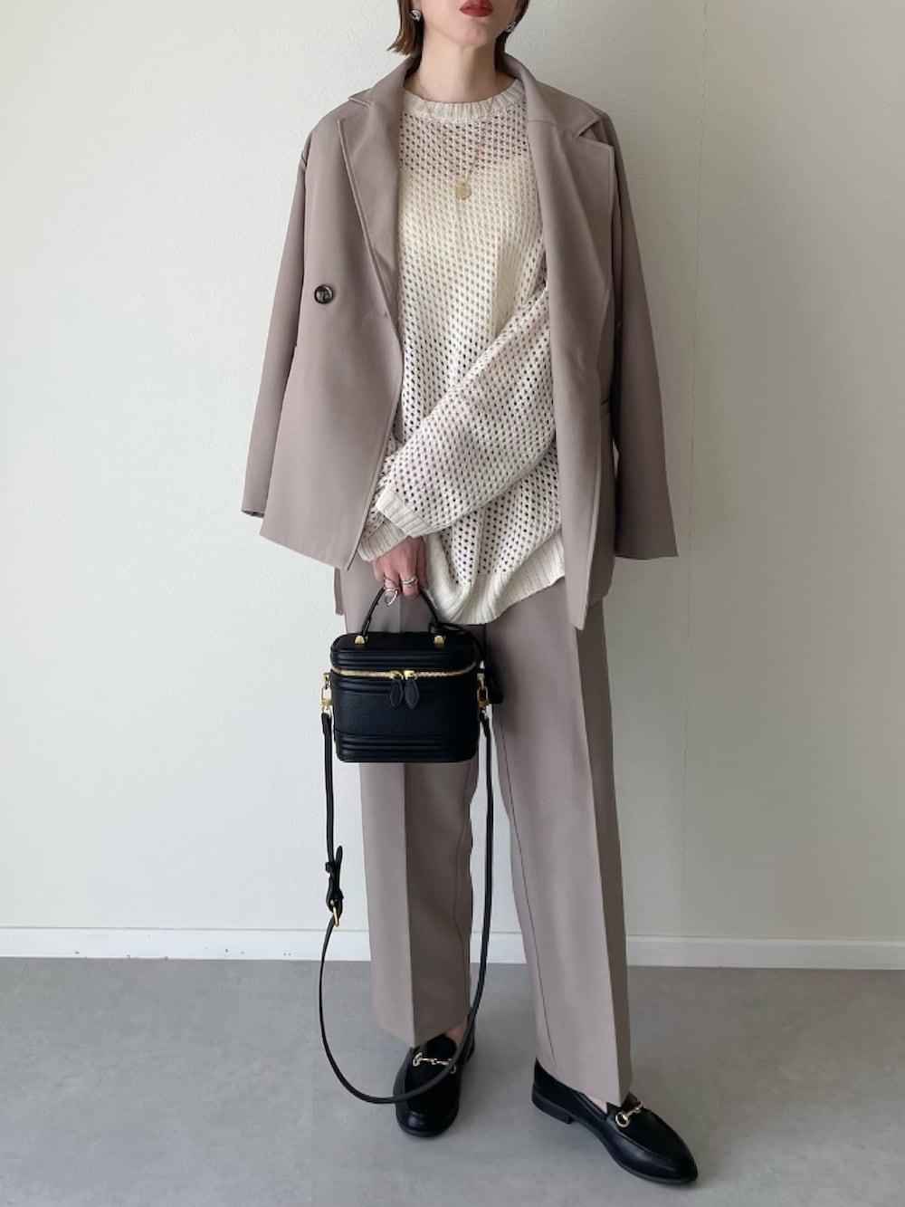 ベージュ系のセットアップ、ホワイト系のニット/セーター、ブラック系のその他シューズを着用したレディースの冬コーディネートの2枚目の写真