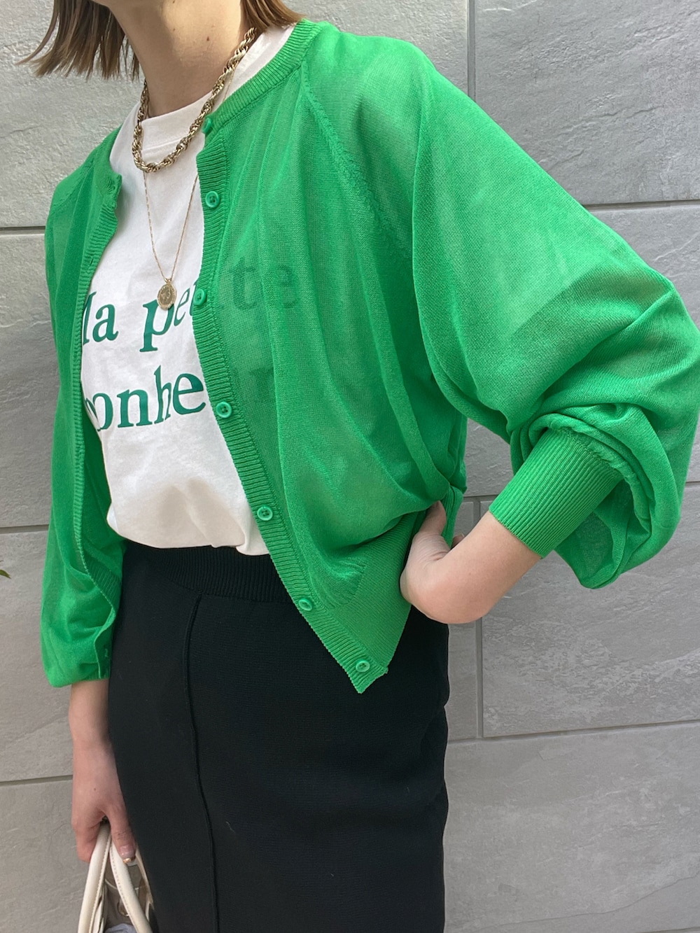 ブラック系のスカート、ホワイト系のサンダル、ホワイト系のショルダーバッグを着用したレディースの春コーディネートの4枚目の写真