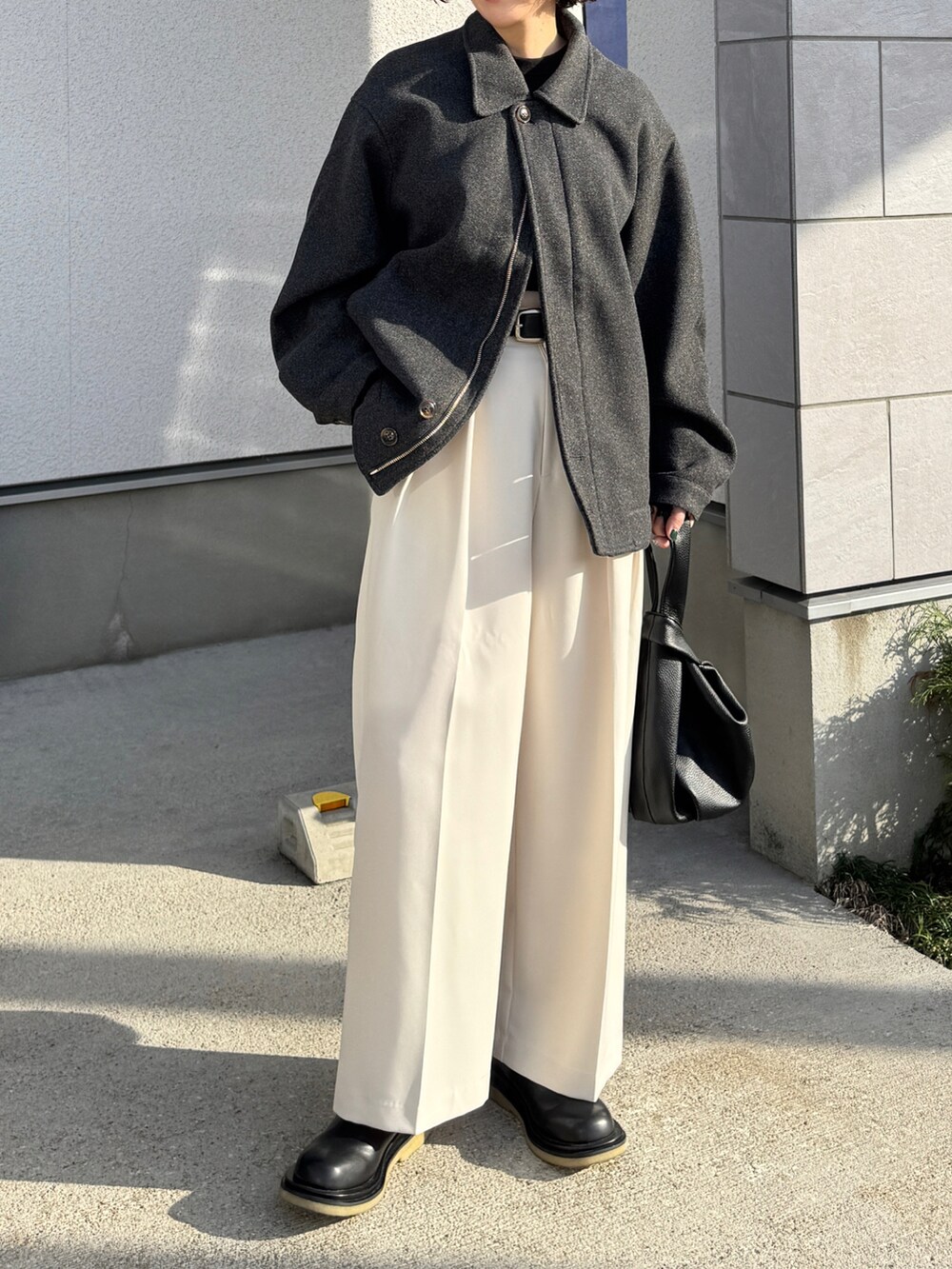 グレー系のその他アウター、ホワイト系のその他パンツ、ブラック系のハンドバッグを着用したレディースの冬コーディネートの4枚目の写真