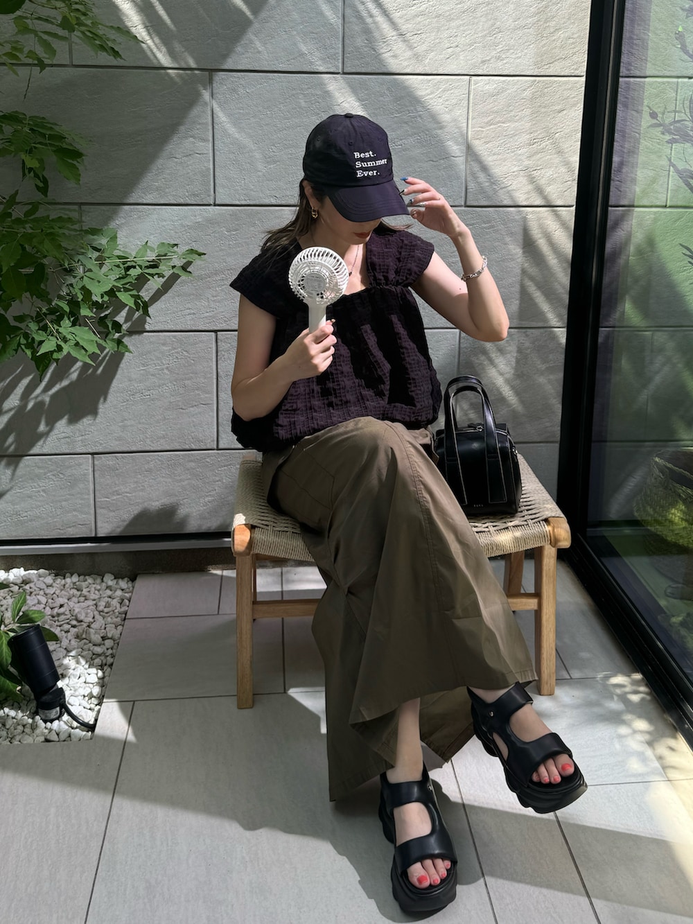 ブラック系のその他トップス、グリーン系のスカート、ブラック系のサンダルを着用したレディースの夏コーディネートの4枚目の写真