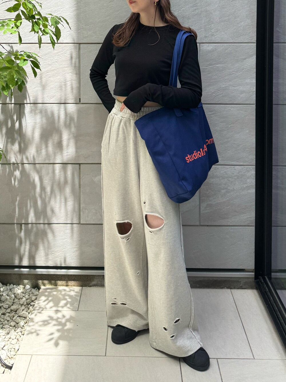 グレー系のスウェットパンツ、ブラック系のTシャツ/カットソー、ブラック系のスニーカーを着用したレディースの春コーディネートの4枚目の写真