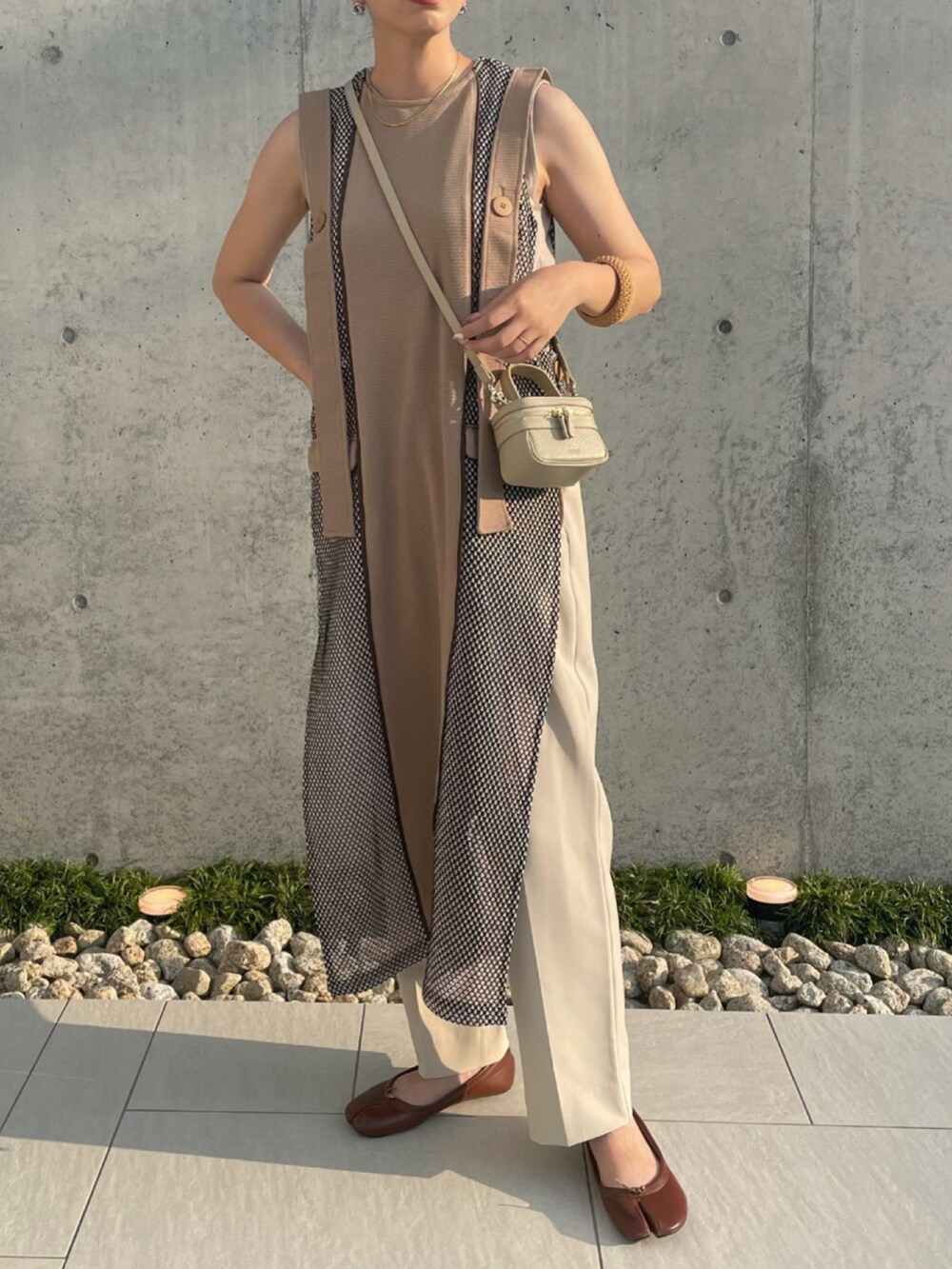 ベージュ系のワンピース、ベージュ系のショルダーバッグ、ブラウン系のパンプスを着用したレディースの夏コーディネートの4枚目の写真