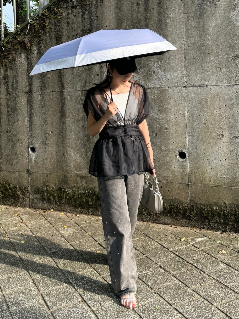 ブラック系のTシャツ/カットソー、ブラック系のデニムパンツ、シルバー系のサンダルを着用したレディースの夏コーディネートの4枚目の写真