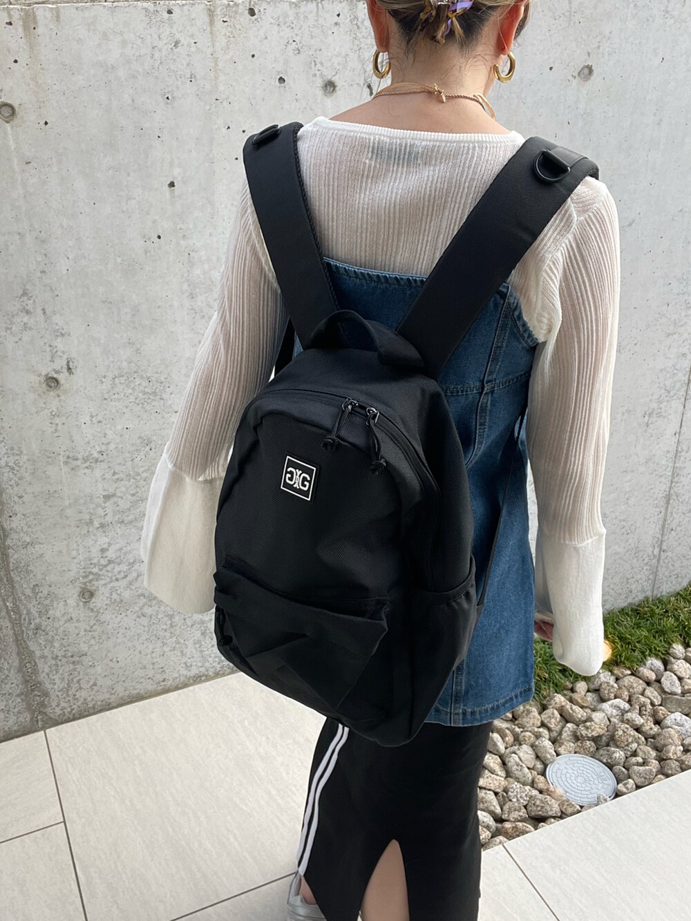 ブラック系のバックパック/リュック、ホワイト系のニット/セーター、グレー系のスニーカーを着用したレディースの秋コーディネートの4枚目の写真