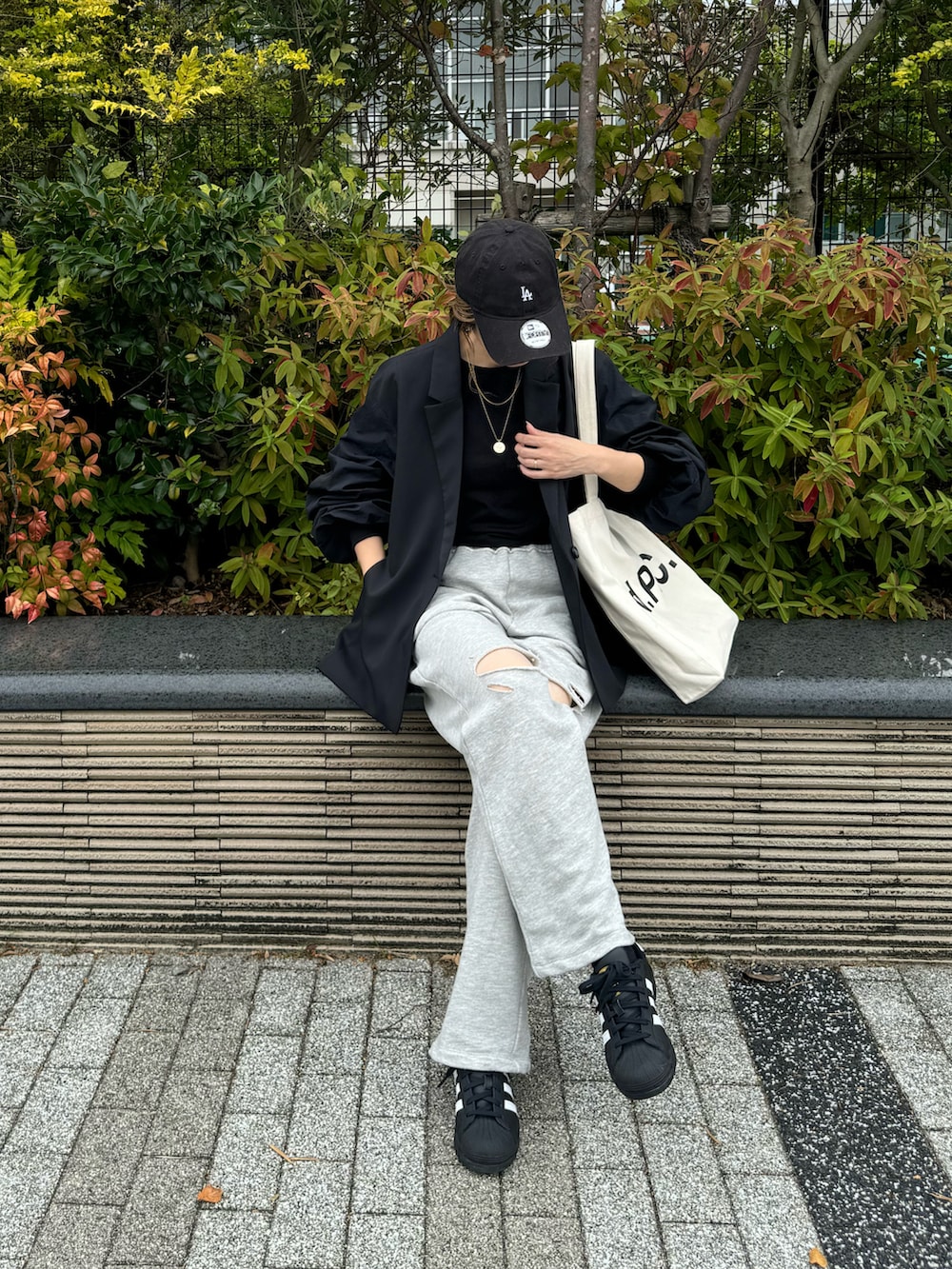 グレー系のスウェットパンツ、ブラック系のスニーカー、ホワイト系のトートバッグを着用したレディースの秋コーディネートの2枚目の写真