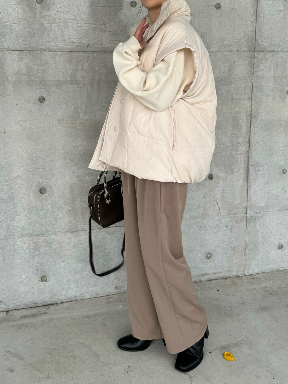 ホワイト系のその他アウター、ブラウン系のその他パンツ、ブラック系のブーツを着用したレディースの秋コーディネートの4枚目の写真