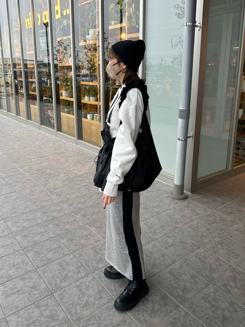 ベージュ系のスウェット、グレー系のスカート、ブラック系のベストを着用したレディースの冬コーディネートの4枚目の写真