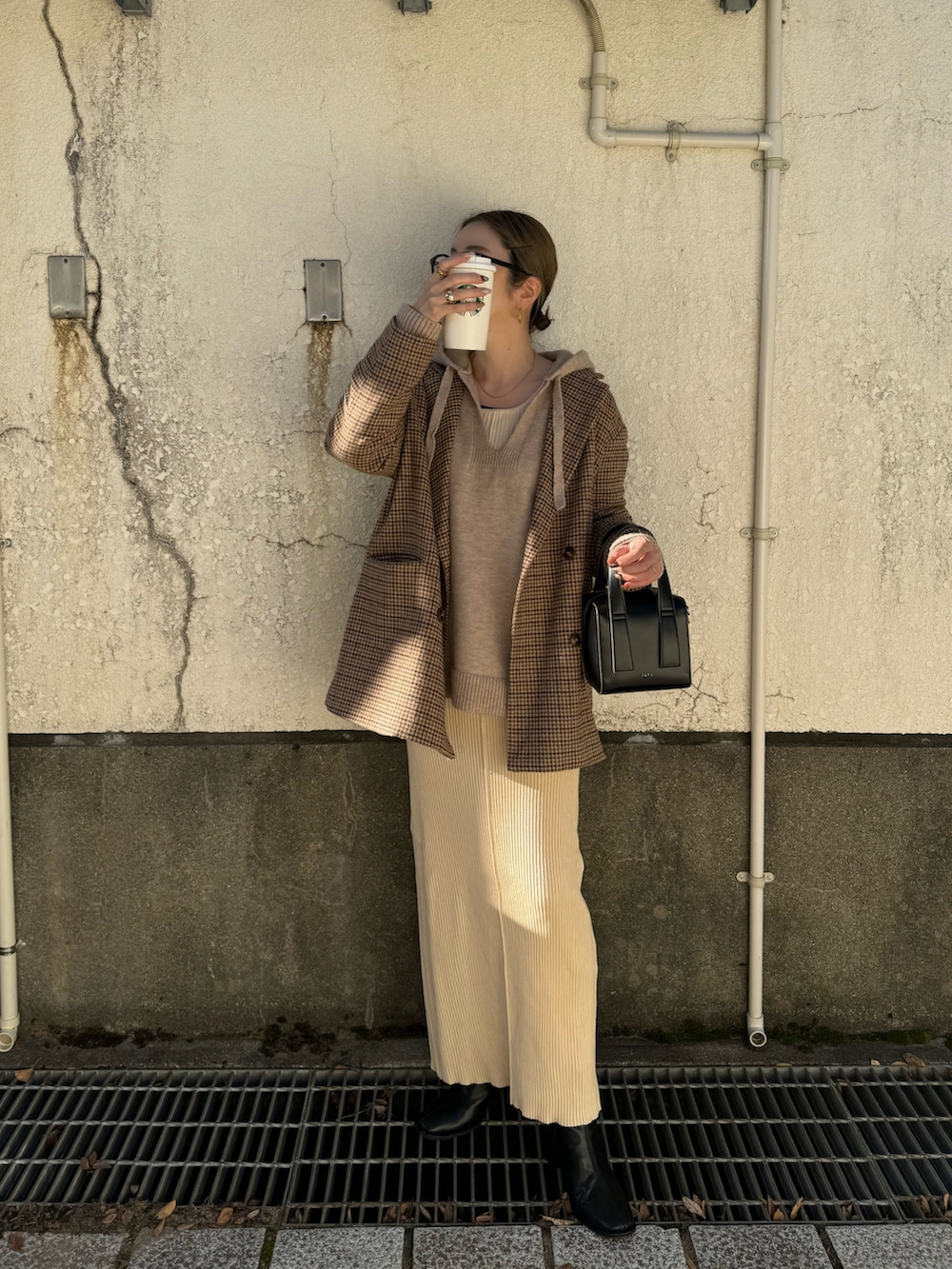 ホワイト系のワンピース、ブラック系のボストンバッグ、ベージュ系のニット/セーターを着用したレディースの秋コーディネートの3枚目の写真