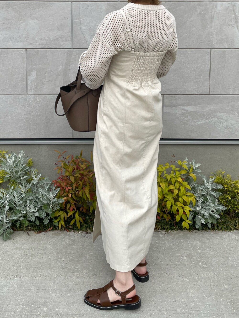 ホワイト系のワンピース、ブラウン系のショルダーバッグ、ブラウン系のサンダルを着用したレディースの春コーディネートの4枚目の写真