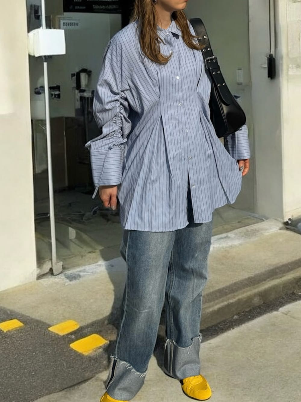 ブルー系のシャツ/ブラウス、イエロー系のスニーカー、ブルー系のデニムパンツを着用したレディースの春コーディネートの2枚目の写真