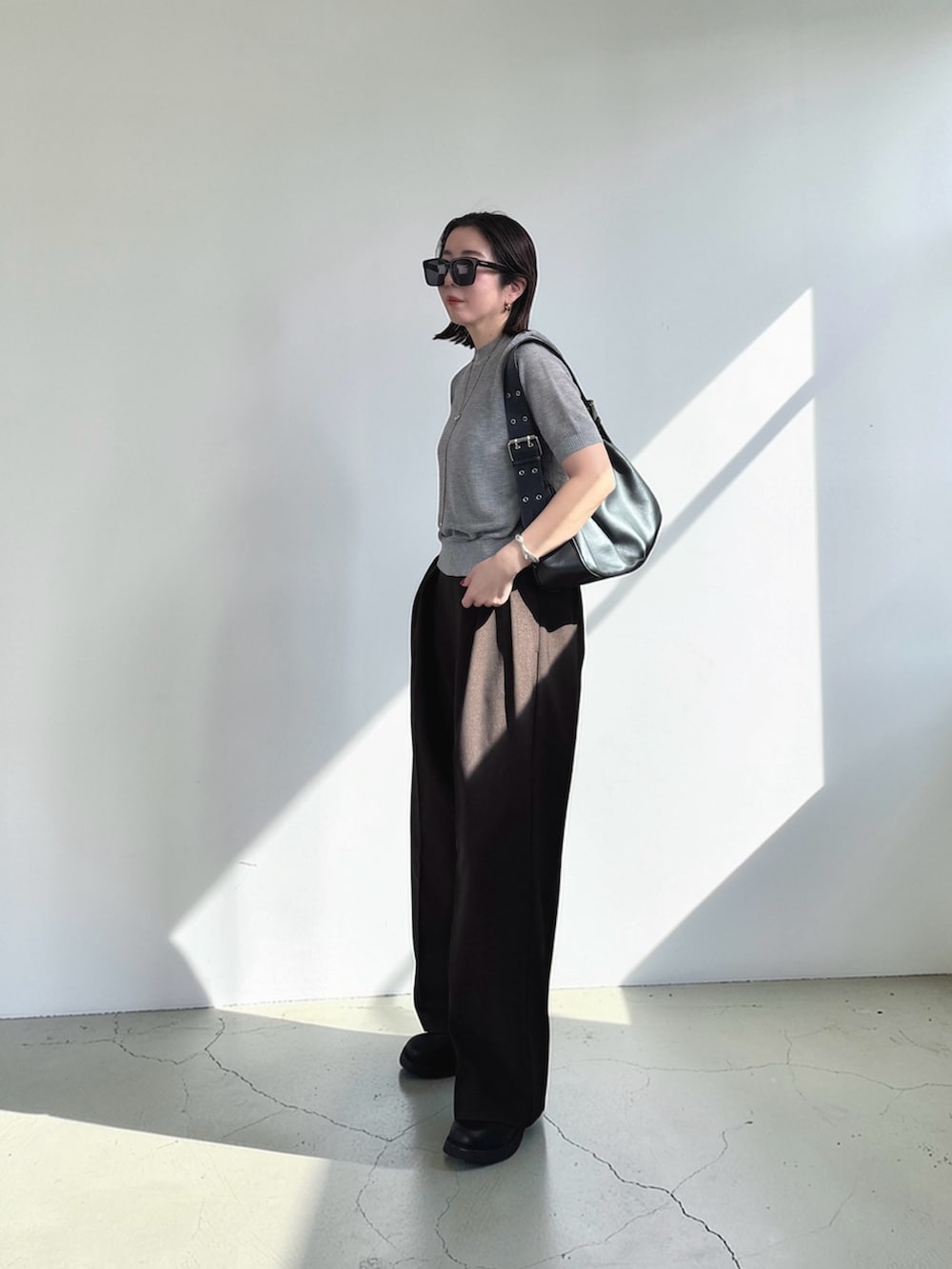 グレー系のニット/セーター、ブラウン系のその他パンツ、ブラック系のその他シューズを着用したレディースの春コーディネートの3枚目の写真