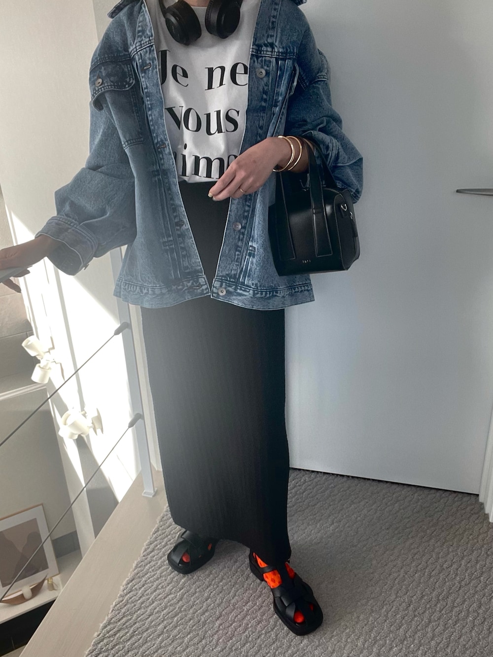 ホワイト系のTシャツ/カットソー、ブラック系のスカート、ブラック系のサンダルを着用したレディースの春コーディネートの4枚目の写真