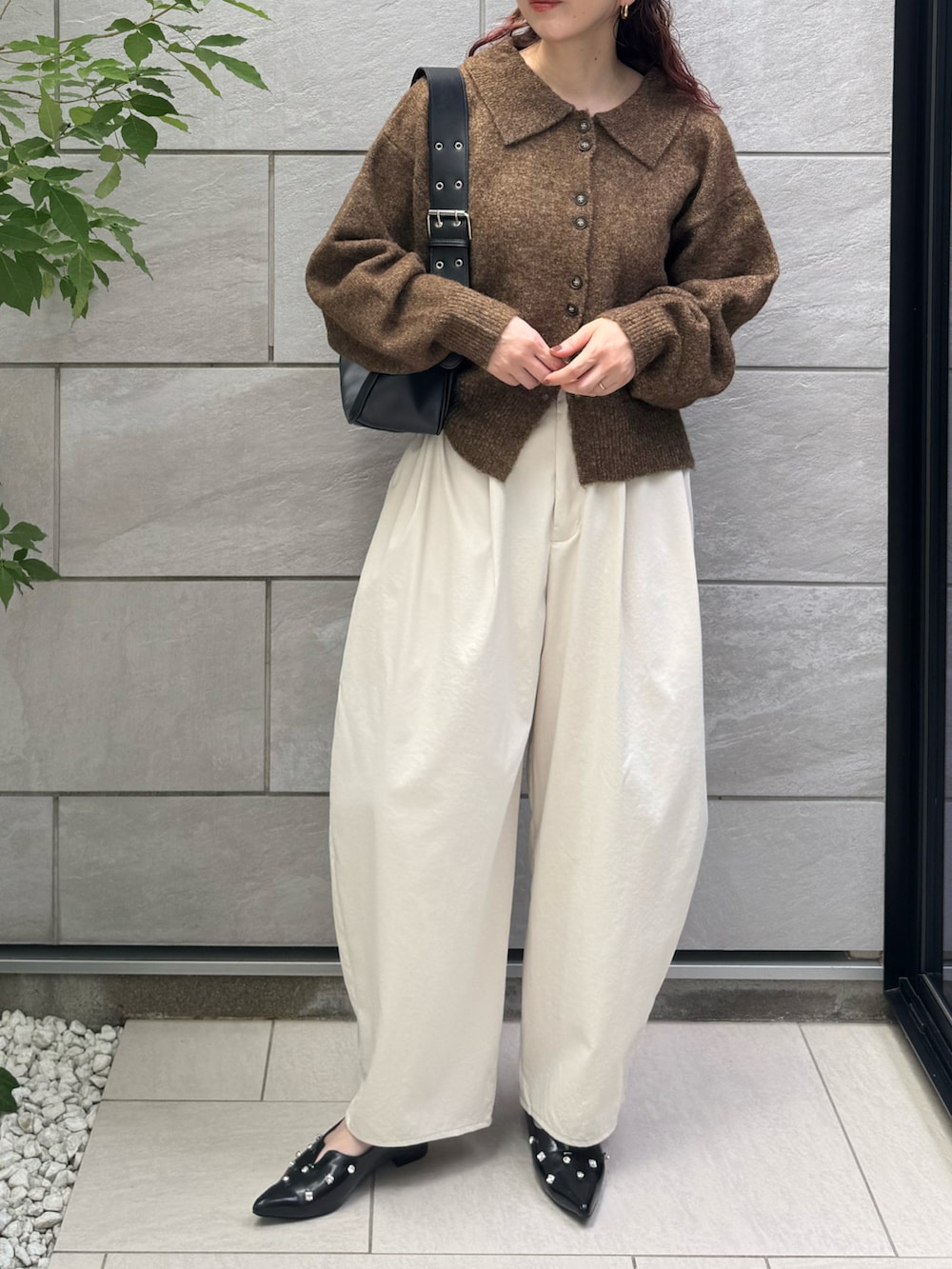 ホワイト系のチノパンツ、ブラック系のパンプス、ブラウン系のカーディガン/ボレロを着用したレディースの秋コーディネートの3枚目の写真