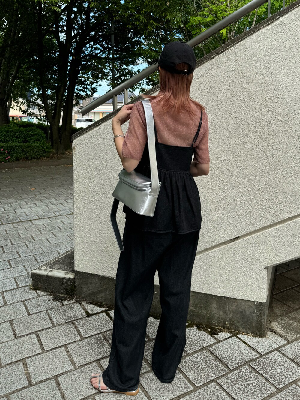 ブラック系のキャミソール、ブラック系のデニムパンツ、シルバー系のサンダルを着用したレディースの夏コーディネートの3枚目の写真