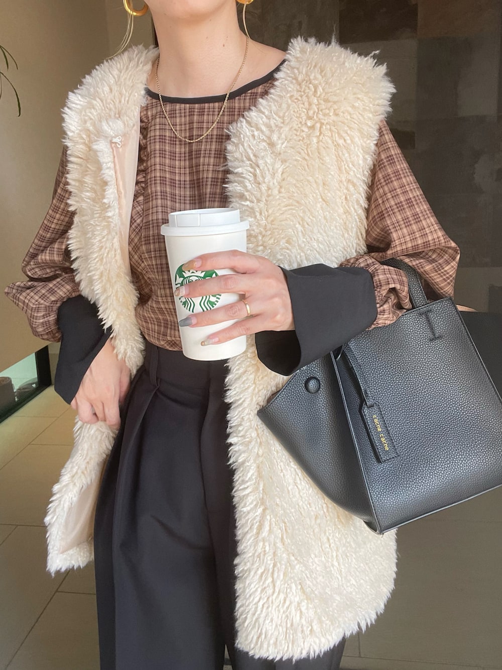 ホワイト系のベスト、ベージュ系のシャツ/ブラウス、ブラック系のその他パンツを着用したレディースの秋コーディネートの2枚目の写真