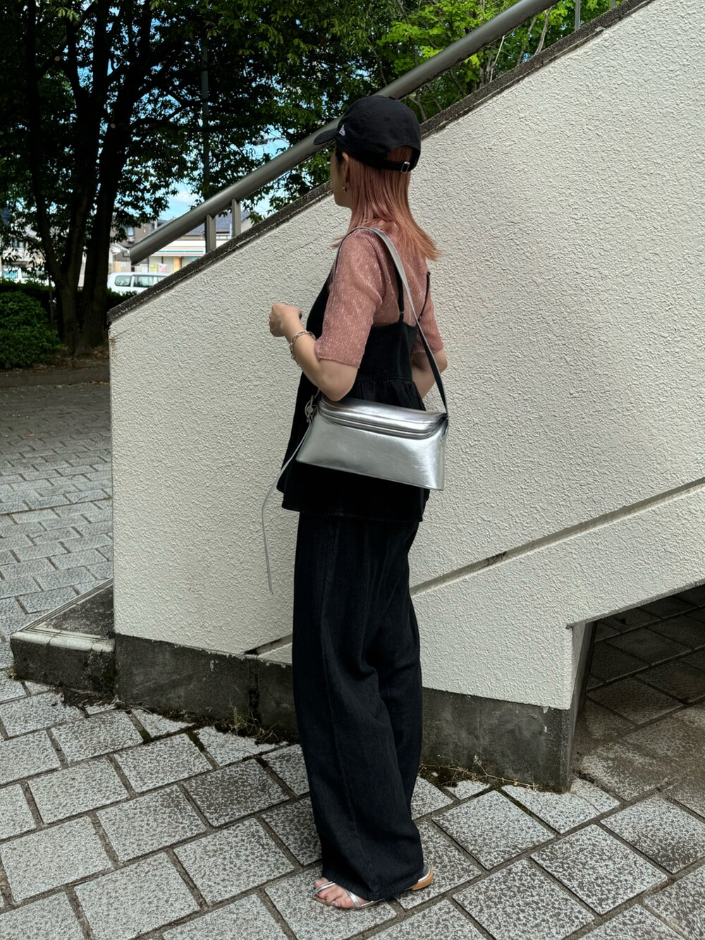 ブラック系のキャミソール、ブラック系のデニムパンツ、シルバー系のサンダルを着用したレディースの夏コーディネートの2枚目の写真