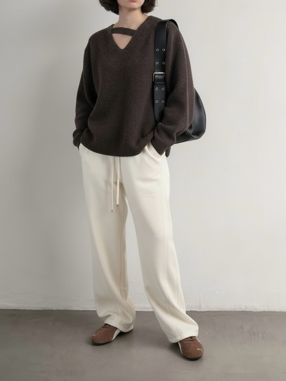 ブラウン系のスニーカー、ブラウン系のニット/セーター、ホワイト系のスウェットパンツを着用したレディースの冬コーディネートの2枚目の写真