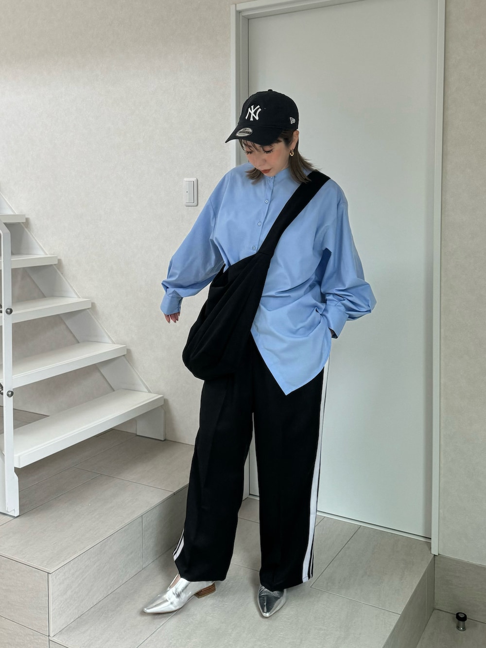 ブルー系のシャツ/ブラウス、ブラック系のスラックス、シルバー系のパンプスを着用したレディースの冬コーディネートの2枚目の写真