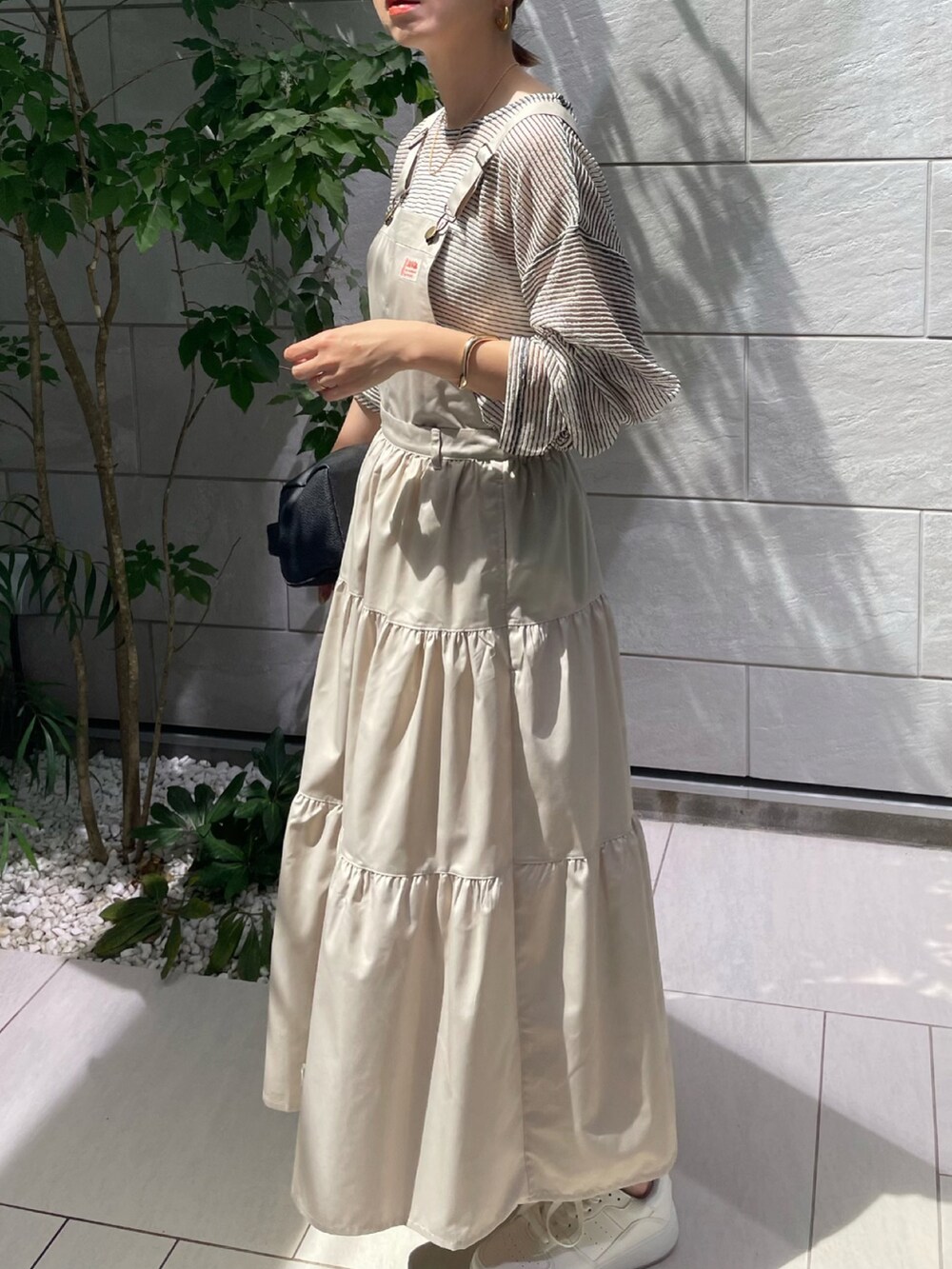 ホワイト系のワンピース、ホワイト系のTシャツ/カットソー、ホワイト系のスニーカーを着用したレディースの春コーディネートの2枚目の写真