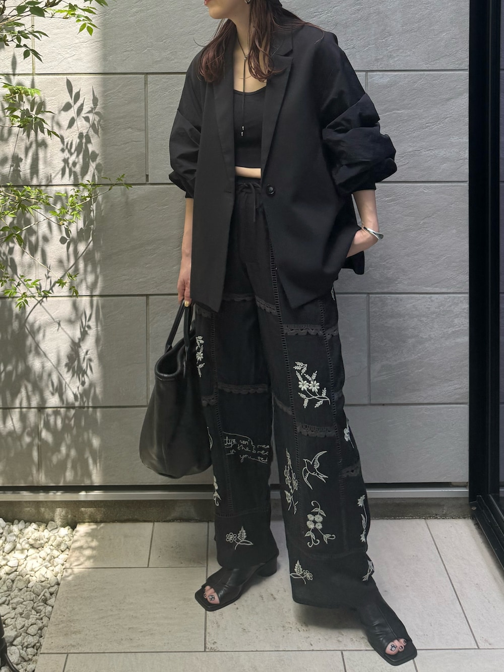 ブラック系のその他パンツ、ブラック系のトートバッグ、ブラック系のニットキャップ/ビーニーを着用したレディースの春コーディネートの2枚目の写真