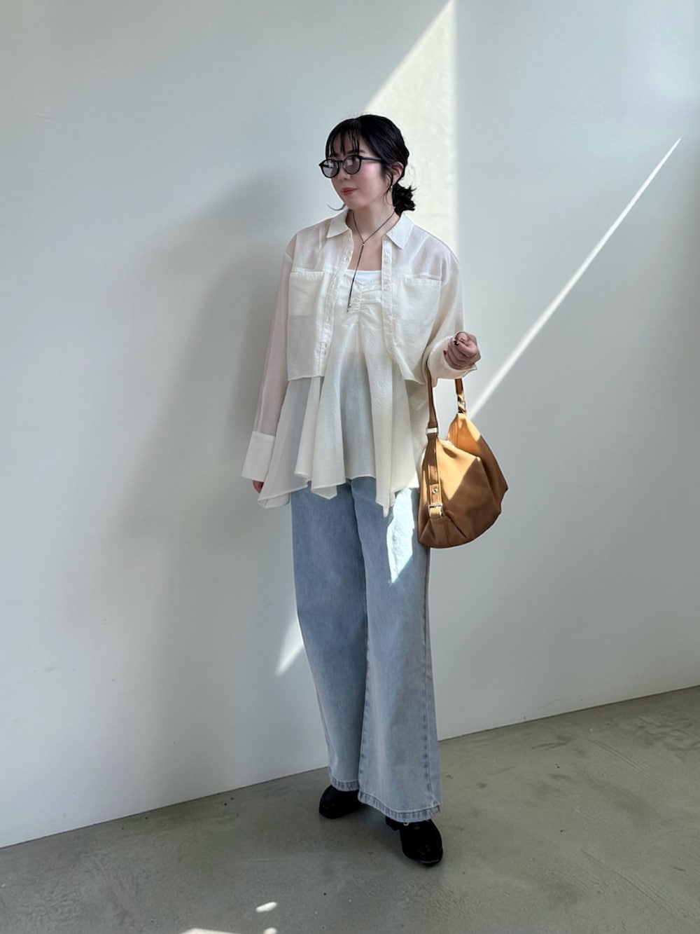 ホワイト系のシャツ/ブラウス、ブルー系のデニムパンツ、イエロー系のショルダーバッグを着用したレディースの春コーディネートの2枚目の写真