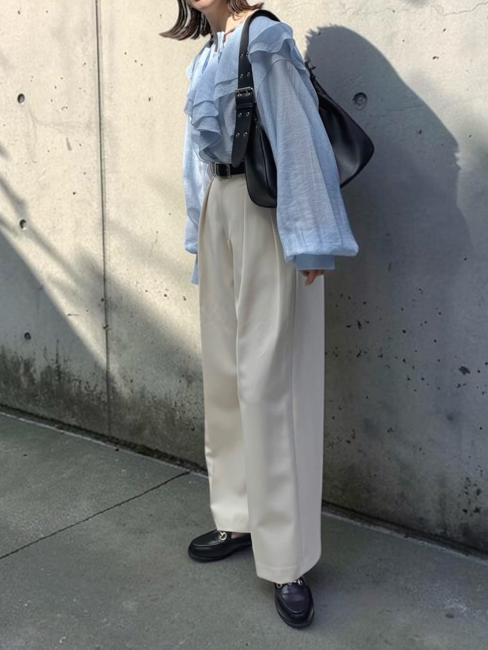 ブルー系のシャツ/ブラウス、ホワイト系のその他パンツ、ブラック系のハンドバッグを着用したレディースの春コーディネートの3枚目の写真
