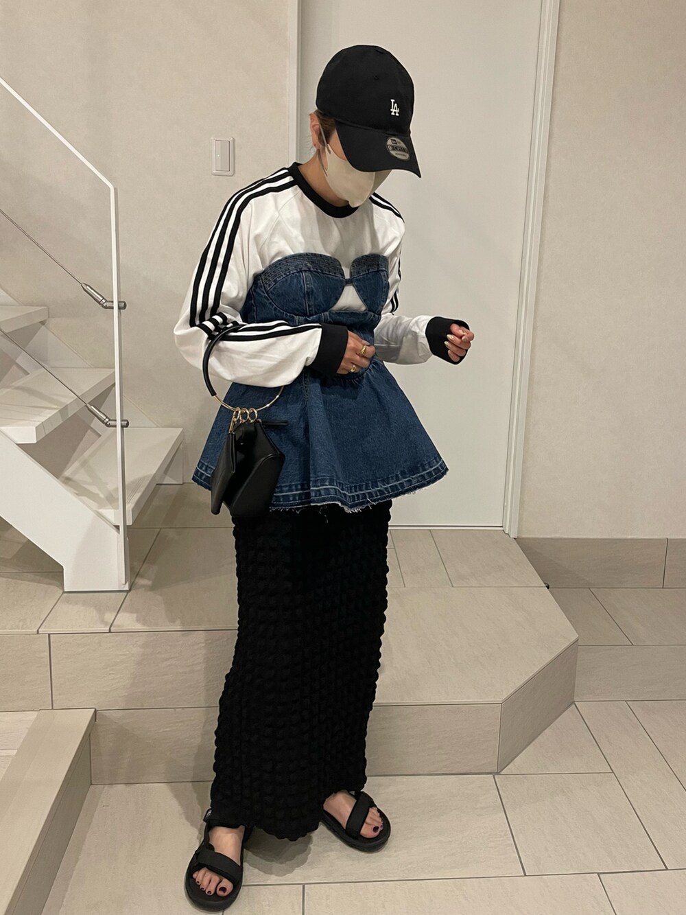 ブラック系のサンダル、ブルー系のTシャツ/カットソー、ブラック系のスカートを着用したレディースの春コーディネートの3枚目の写真