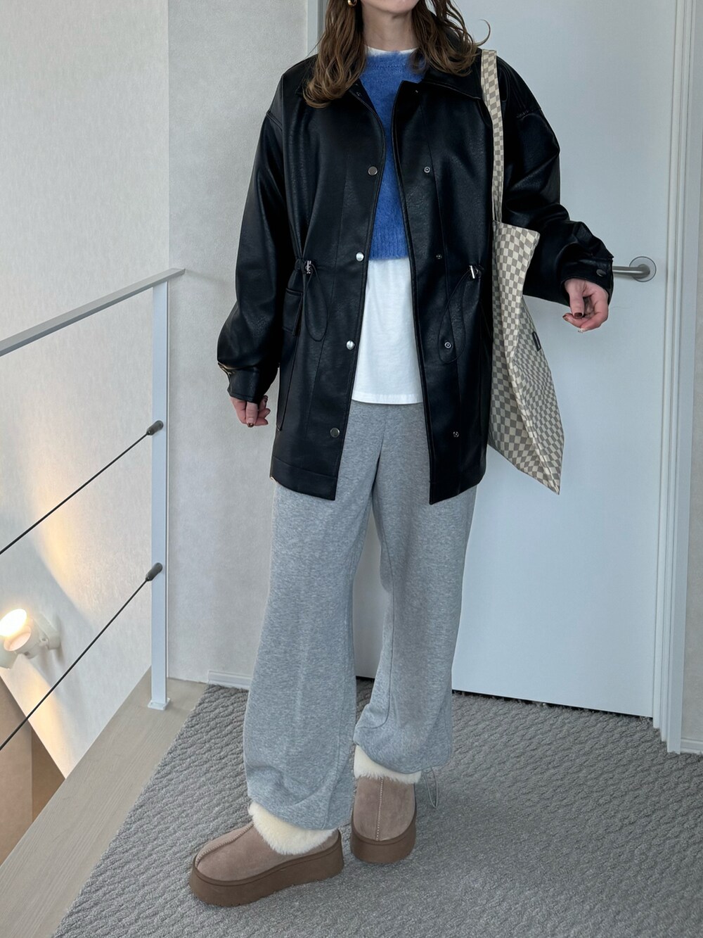 ブラック系のその他アウター、グレー系のスウェットパンツ、ベージュ系のトートバッグを着用したレディースの冬コーディネートの3枚目の写真